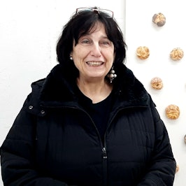 Ellen Loh-Bachmann zwischen Narrenkappe und auf einer Wandtafel befestigten Brötchen.