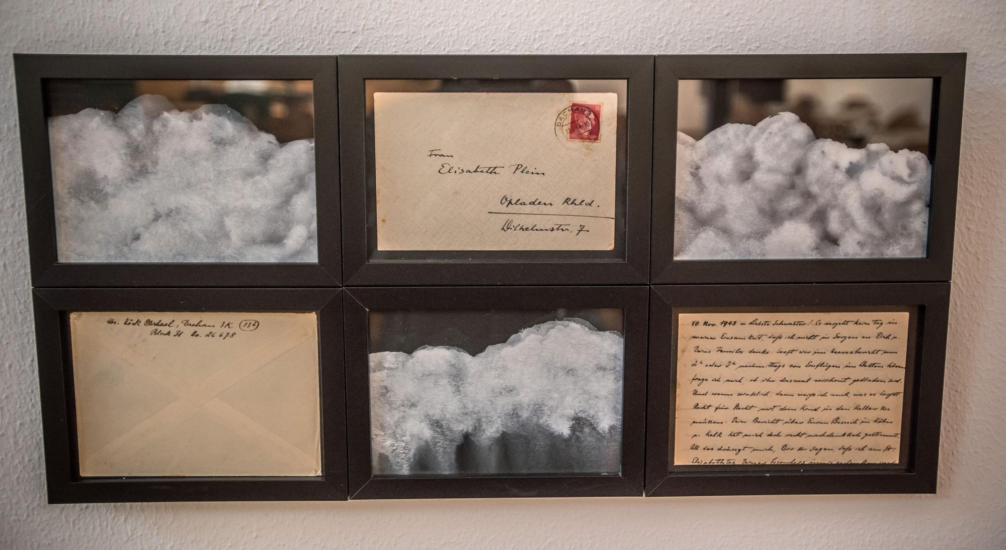 Ein Kunstwerk mit gerahmten Briefen und Wolkenbildern.