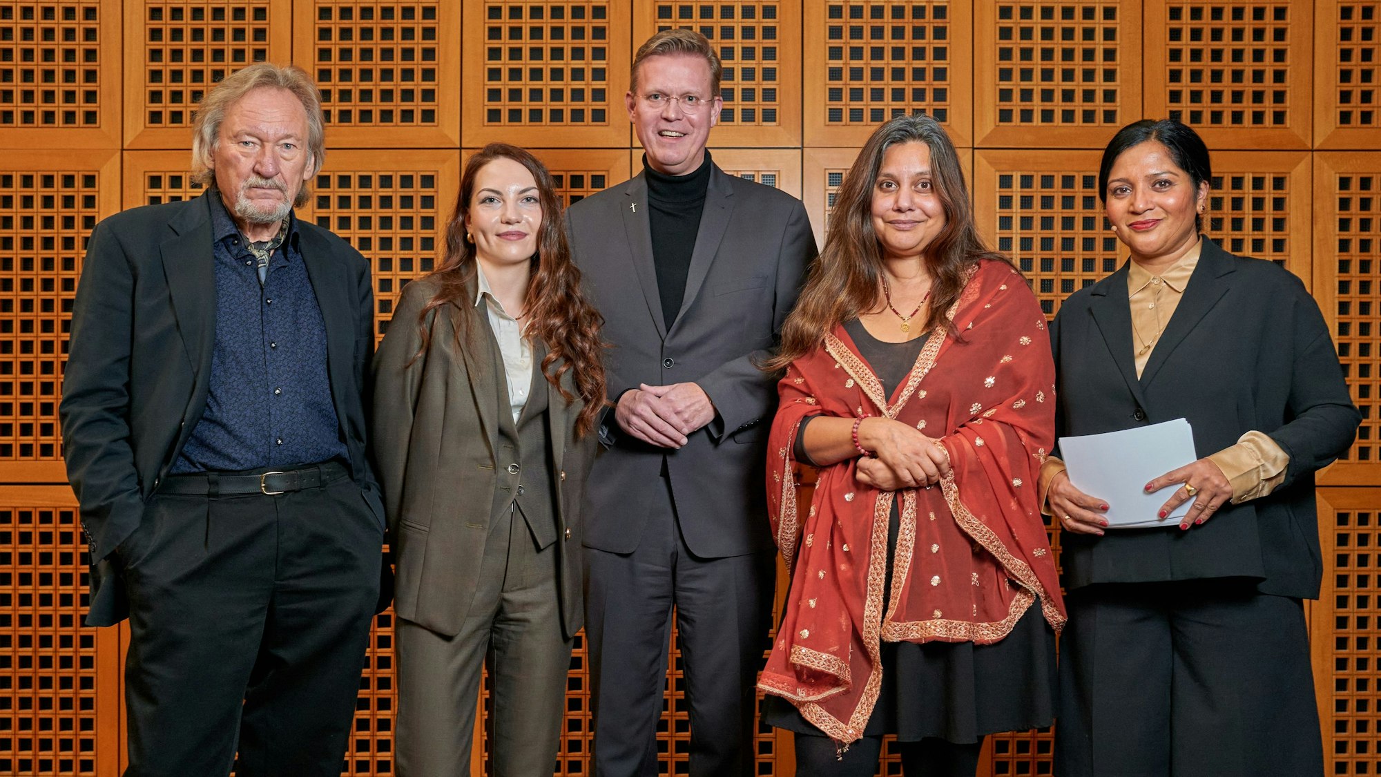 Professor Klaus Theweleit, Patricia Engel, Dominik Meiering, Mithu Sanyal und die Moderatorin Prasanna Oommen schauen vor der Podiumsdiskussion zur Susanna-Ausstellung gemeinsam in die Kamera.