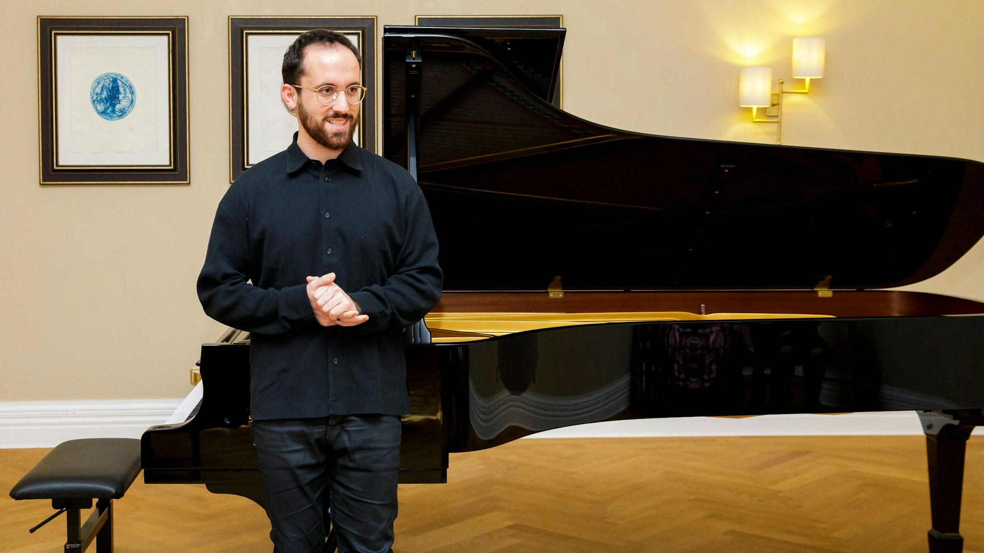 Igor Levit steht vor einem Flügel.