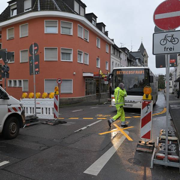 Ein Transporter steht vor einem Durchfahrt-Verboten-Schild in Bergisch Gladbach, ihm gegenüber steht ein Bus, davor ein Fußgänger.