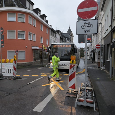 Ein Transporter steht vor einem Durchfahrt-Verboten-Schild in Bergisch Gladbach, ihm gegenüber steht ein Bus, davor ein Fußgänger.