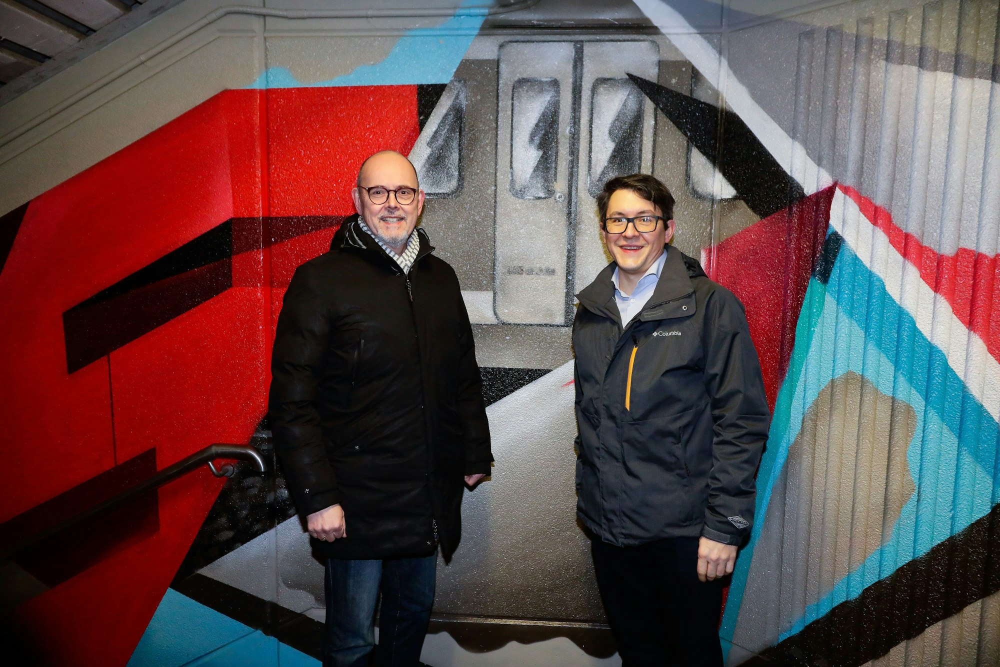 Das Bikd zeigt Kai Rossman (DB Manager) und Wilfried Koenen (Bereichleiter Rheinland) vor der neuen Grafitti-Wand im Bahnhof Nippes.