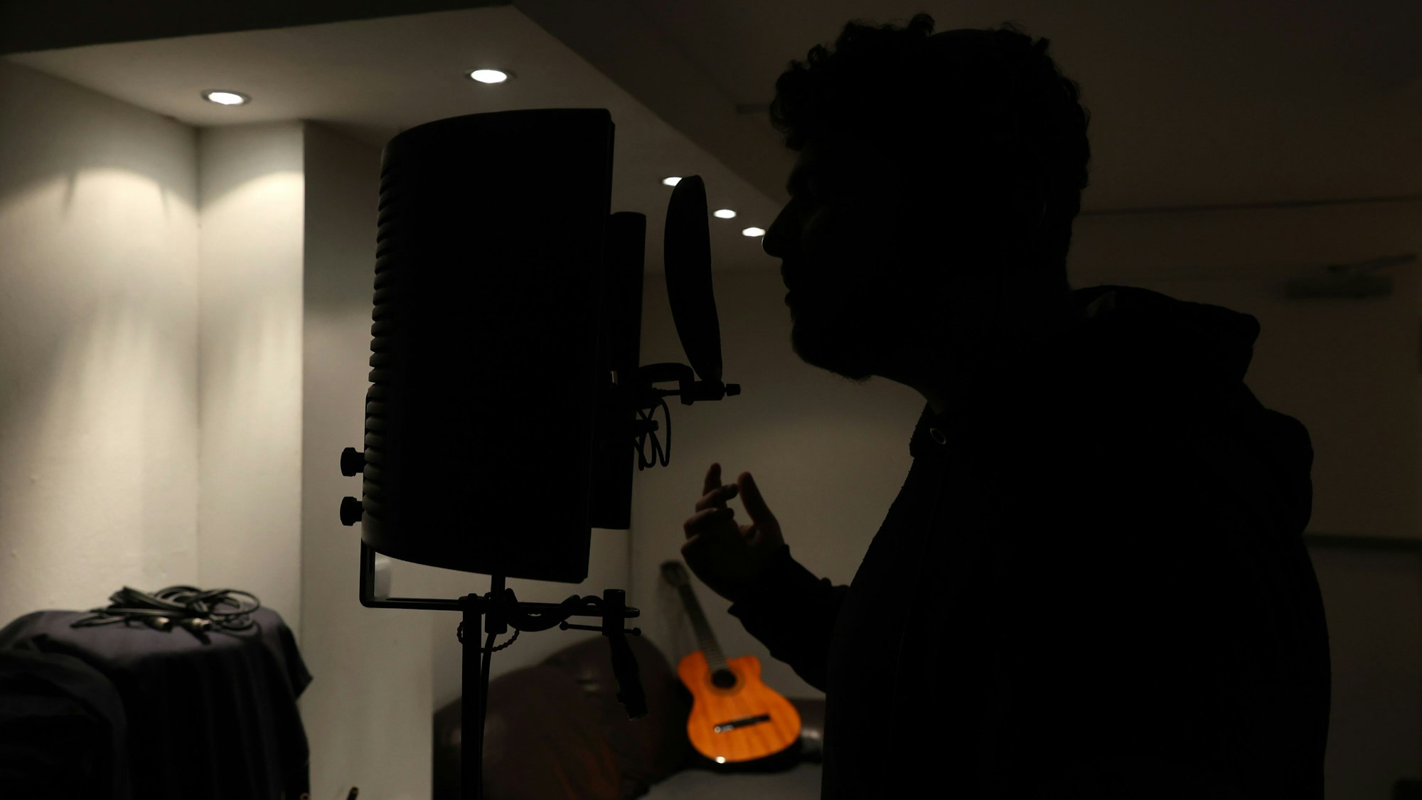 Cristiano sitzt in einem Tonstudio und singt in ein Mikrofon