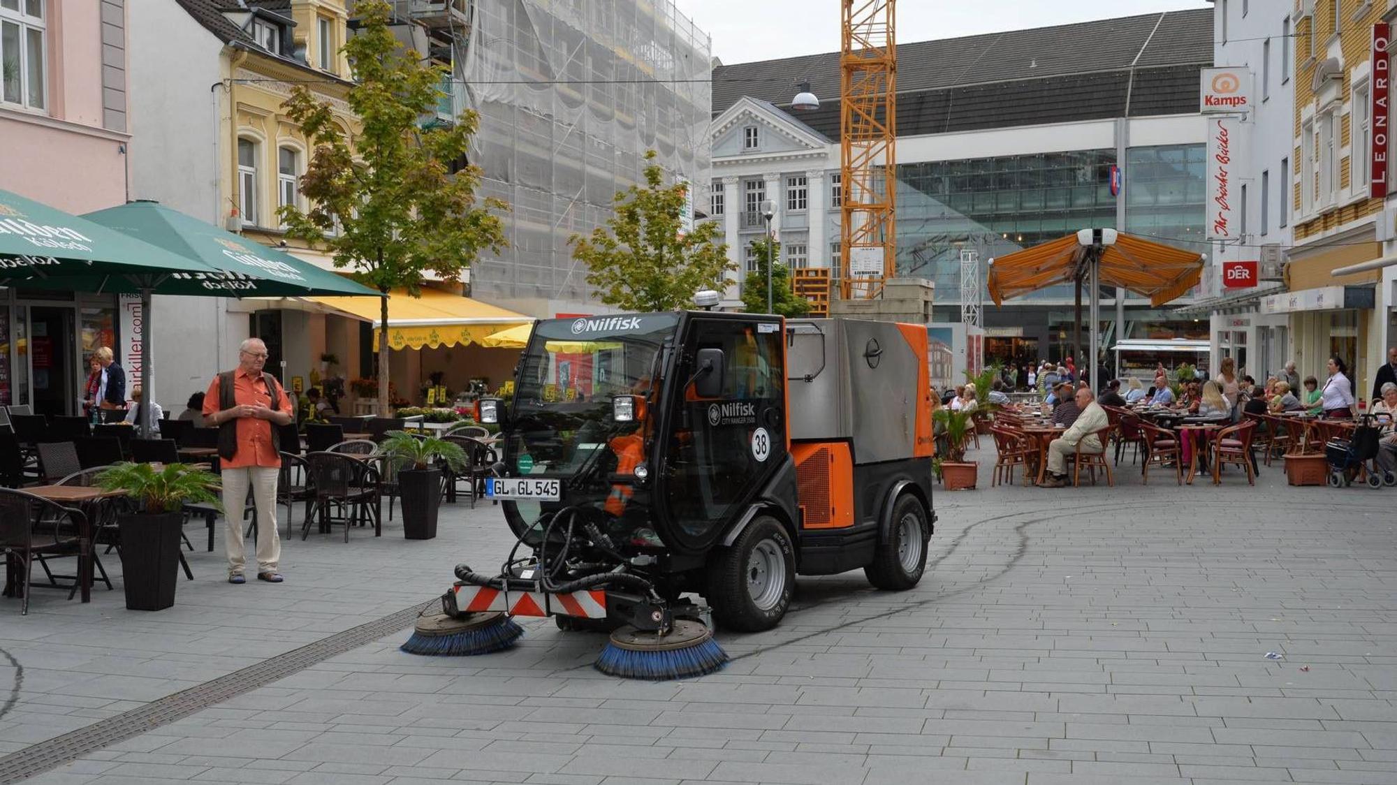 Es ist eine Kehrmaschine in der Fußgängerzone in Bergisch Gladbach zu sehen.