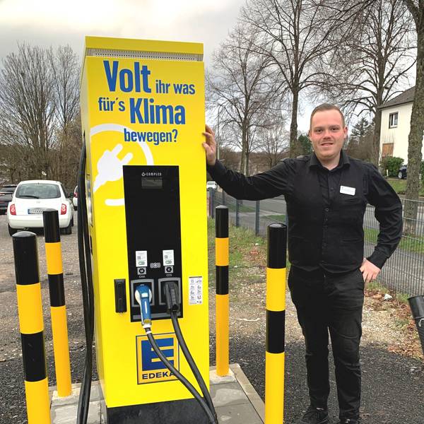 Manuel Marquardt, stellvertretender Leiter des Edeka-Marktes in Witzhelden, steht neben der gelben Elektro-Ladesäule auf dem Parkplatz an der Solinger Straße.