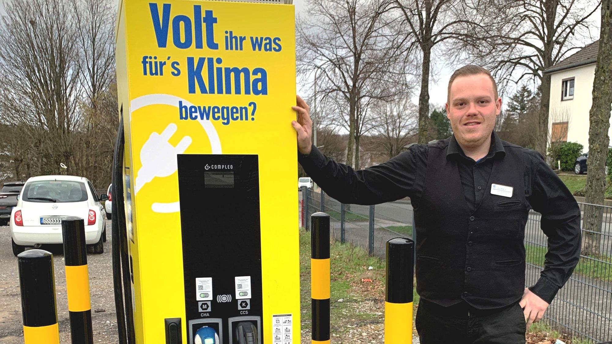 Manuel Marquardt, stellvertretender Leiter des Edeka-Marktes in Witzhelden, steht neben der gelben Elektro-Ladesäule auf dem Parkplatz an der Solinger Straße.