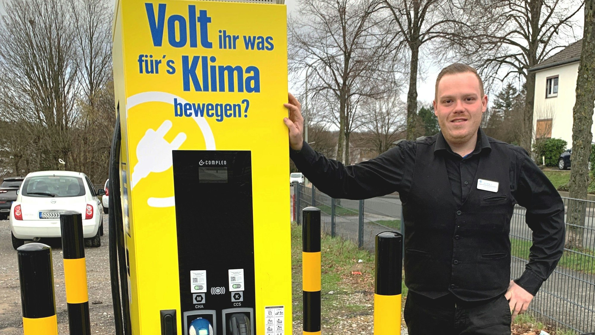 Manuel Marquardt, stellvertretender Leiter des Edeka-Marktes in Witzhelden, steht neben der gelben Elektro-Ladesäule auf dem Parkplatz an der Solinger Straße.
