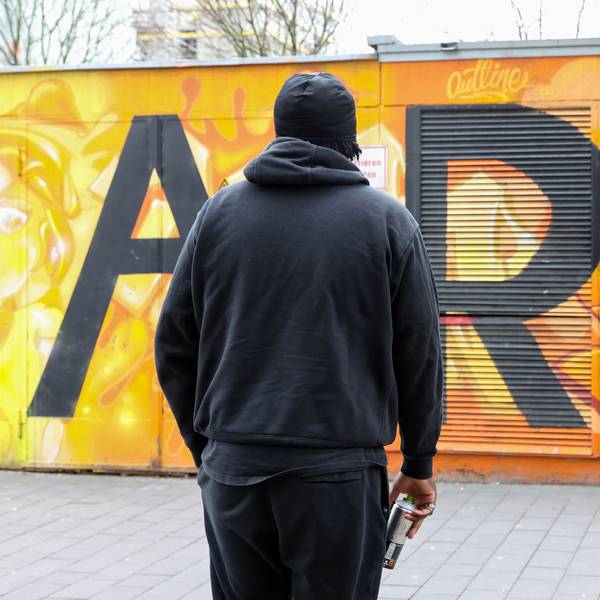 Der 19-jährige Chris schaut auf eine mit Graffiti besprühte Mauer. Es ist nur sein Rücken zu sehen, Chris möchte anonym bleiben.