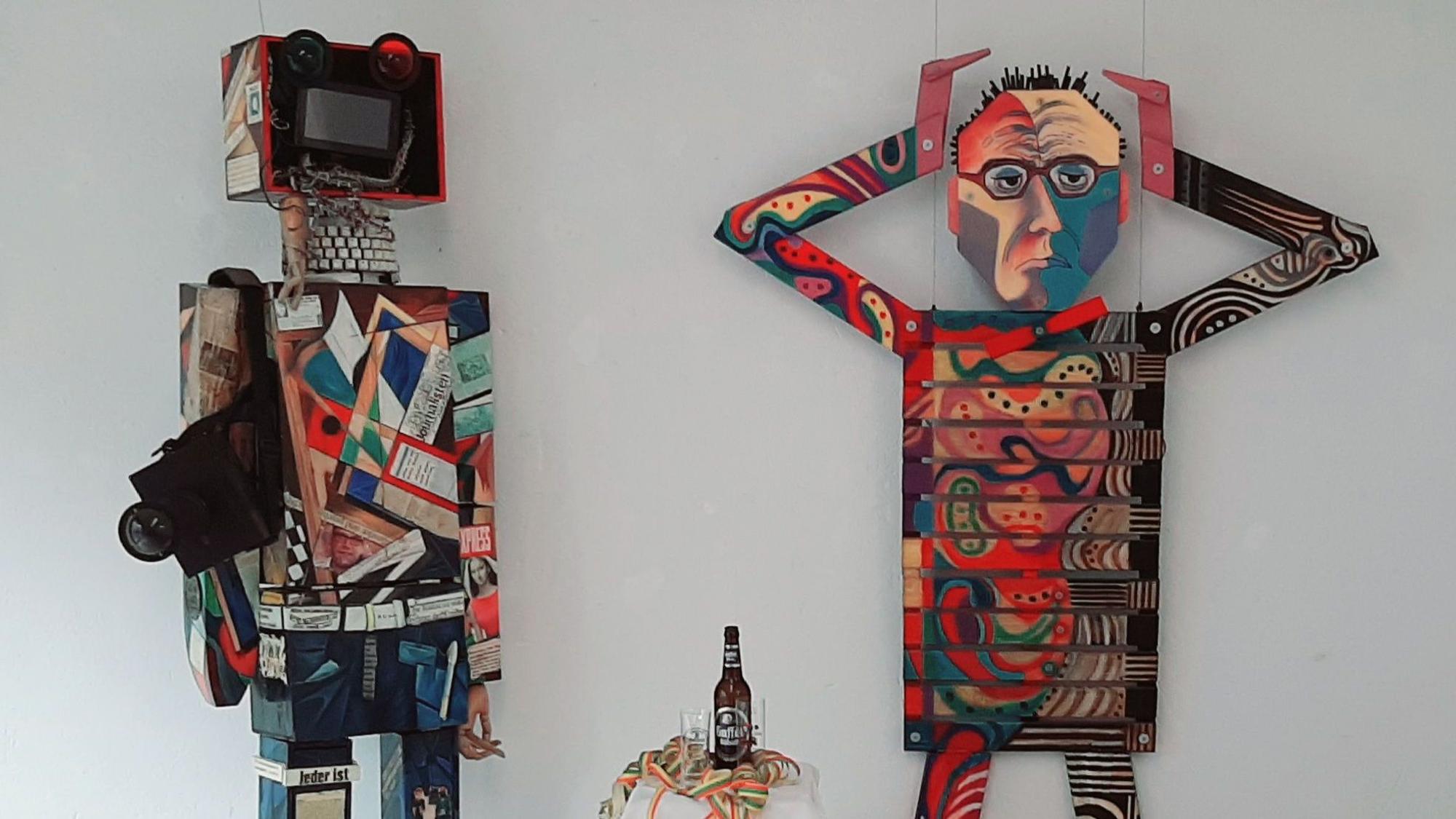 Zwei Figuren aus Blech, Holz, Karton.