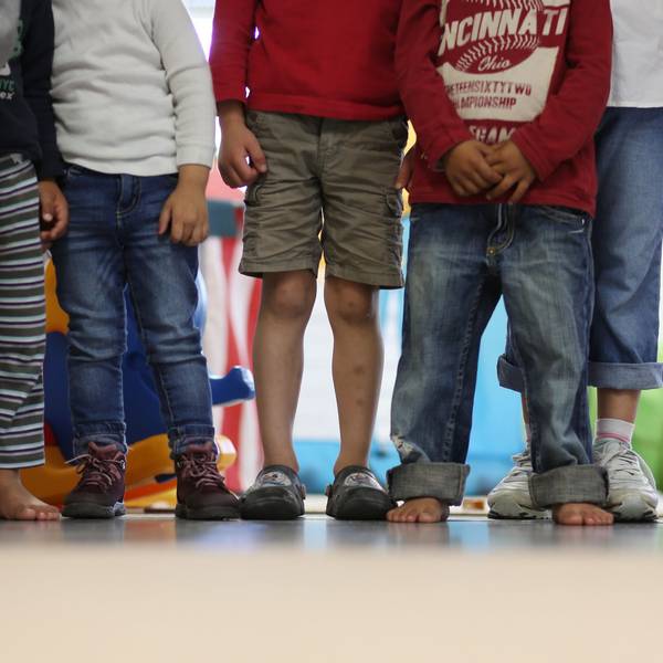 Es sind Füße und Beine von Kindern zu sehen, die nebeneinander stehen.