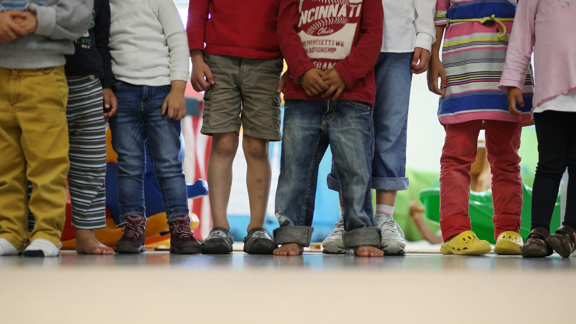 Kinder stehen in einem Kindergarten.