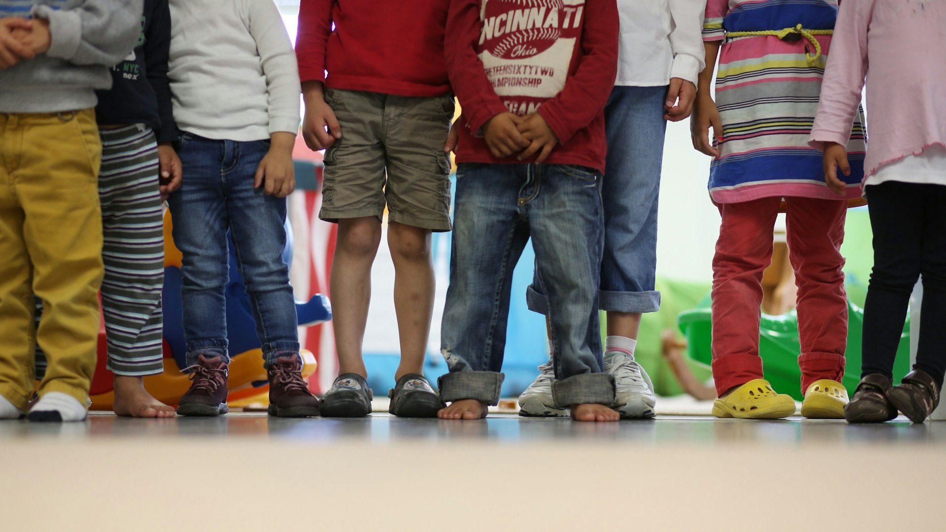 Kinder stehen in einem Kindergarten.