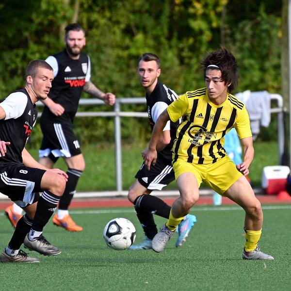 Ein Fußballspieler geht gegen seinen Gegner ins Dribbling.