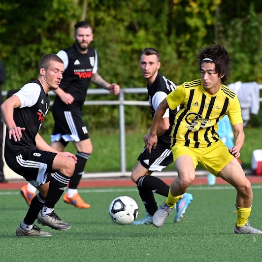Ein Fußballspieler geht gegen seinen Gegner ins Dribbling.