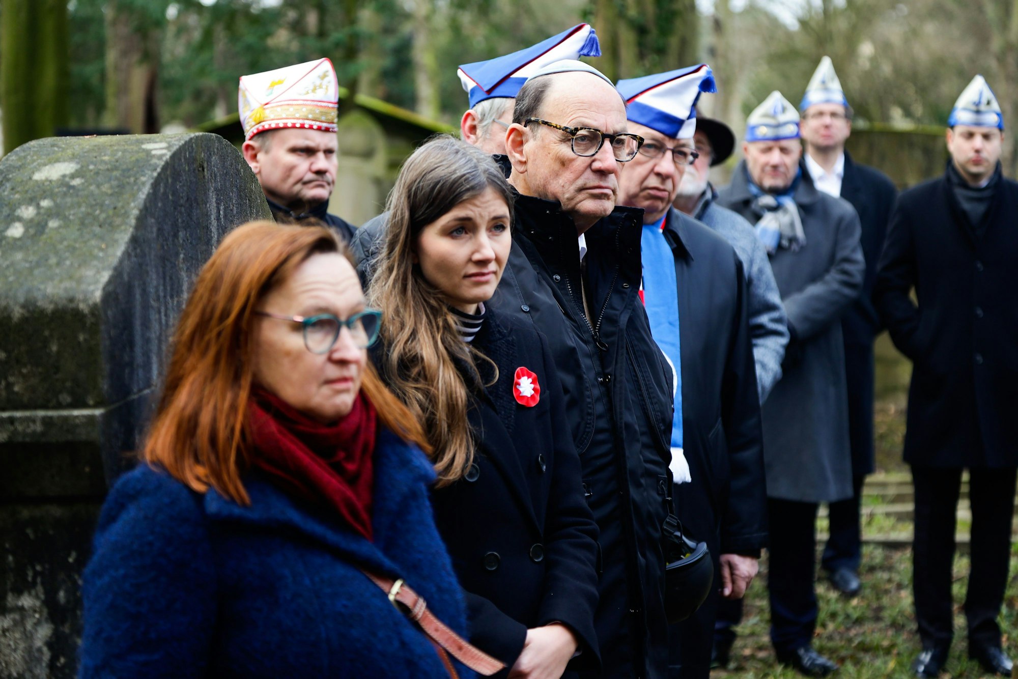 Michael Rado und einige Nachkommen von Emil Jülich hören einem Redner bei der Gedenkstunde für jüdische Karnevalisten zu.