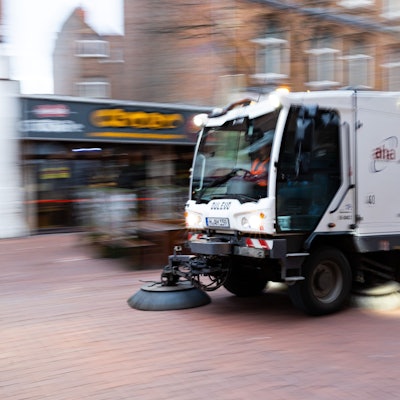 Eine Kehrmaschine fährt in einer Fußgängerzone.