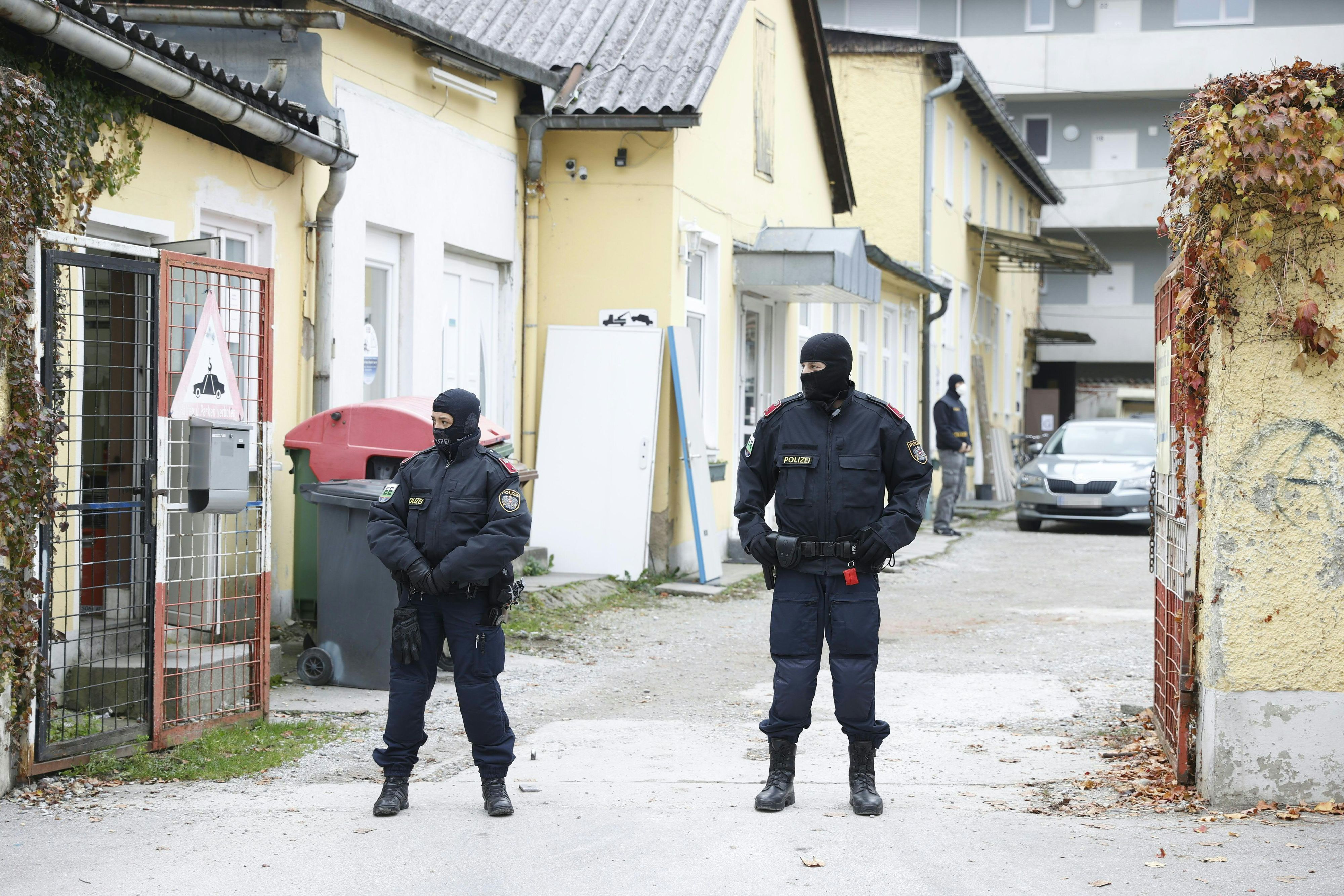 Österreichische Polizisten stehen vor einem Haus. (Symbolbild)