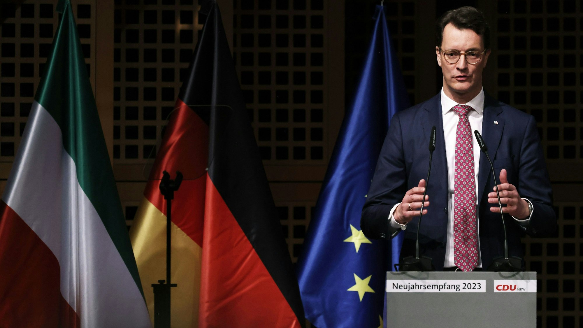 Der nordrhein-westfälische Ministerpräsident Hendrik Wüst (CDU) spricht beim CDU Neujahrsempfang in Düsseldorf. Im Hintergrund sind die Flaggen von Nordrhein-Westfalen, Deutschland und der Europäischen Union.