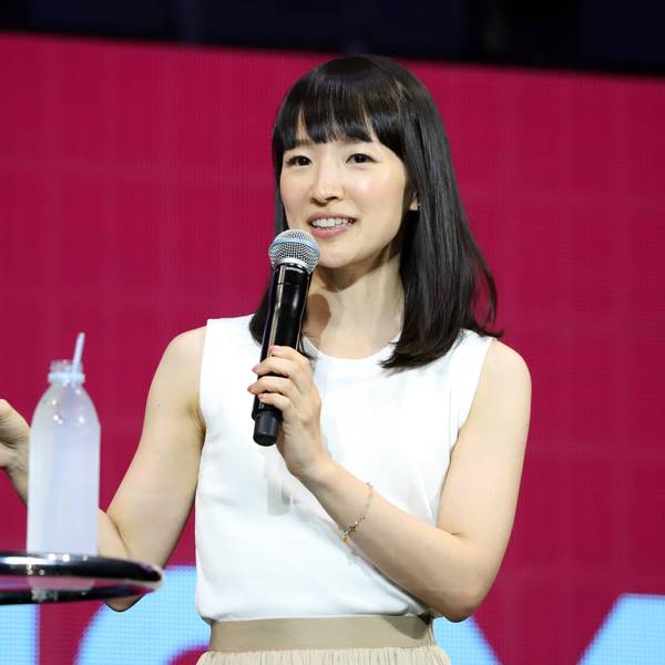 Aufräum-Expertin Marie Kondo 2019 bei einem Vortrag in Japan. Sie trägt ein weißes Oberteil, gestikuliert mit der rechten Hand und hält ein Mikrofon.