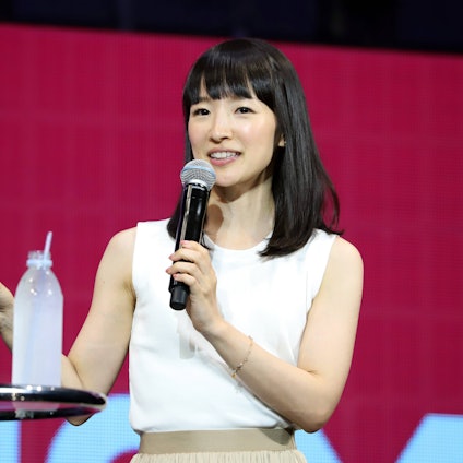 Aufräum-Expertin Marie Kondo 2019 bei einem Vortrag in Japan. Sie trägt ein weißes Oberteil, gestikuliert mit der rechten Hand und hält ein Mikrofon.