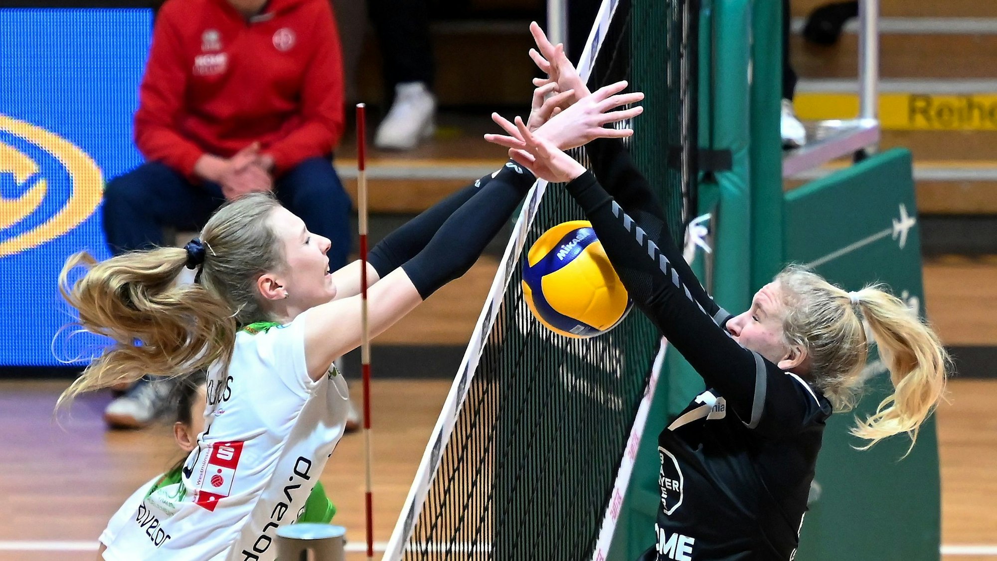 Zwei Volleyballspielerinnen kämpfen am Netz um einen Punkt.