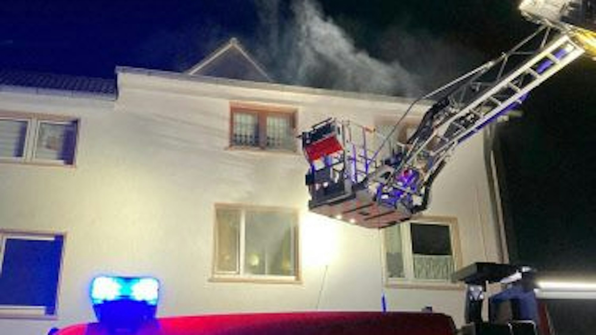 Mit ausgefahrener Drehleiter nähert sich die Feuerwehr dem Brandherd.