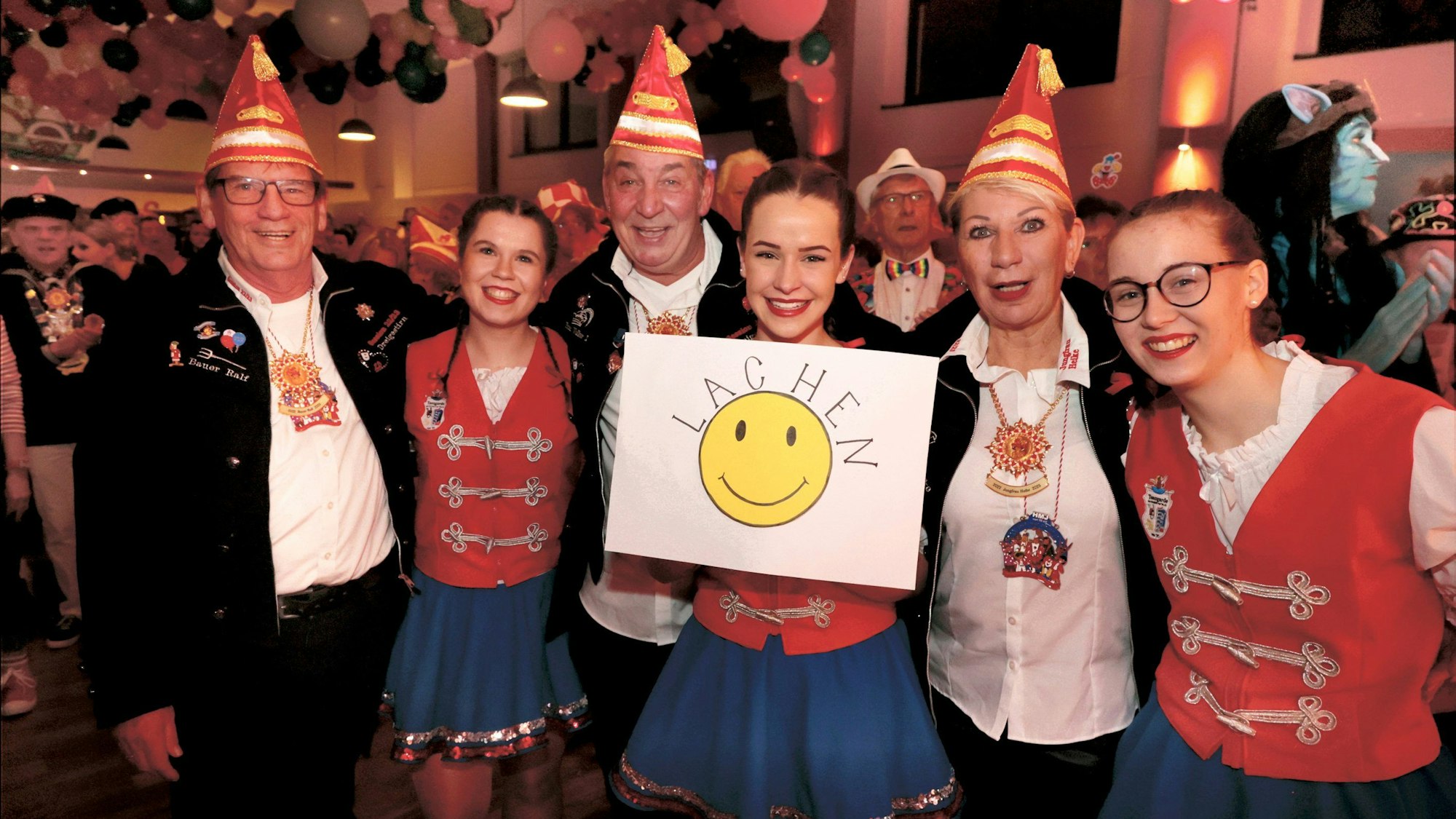 Gruppe von Karnevalisten mit einem Schild, auf dem „Lachen“ steht