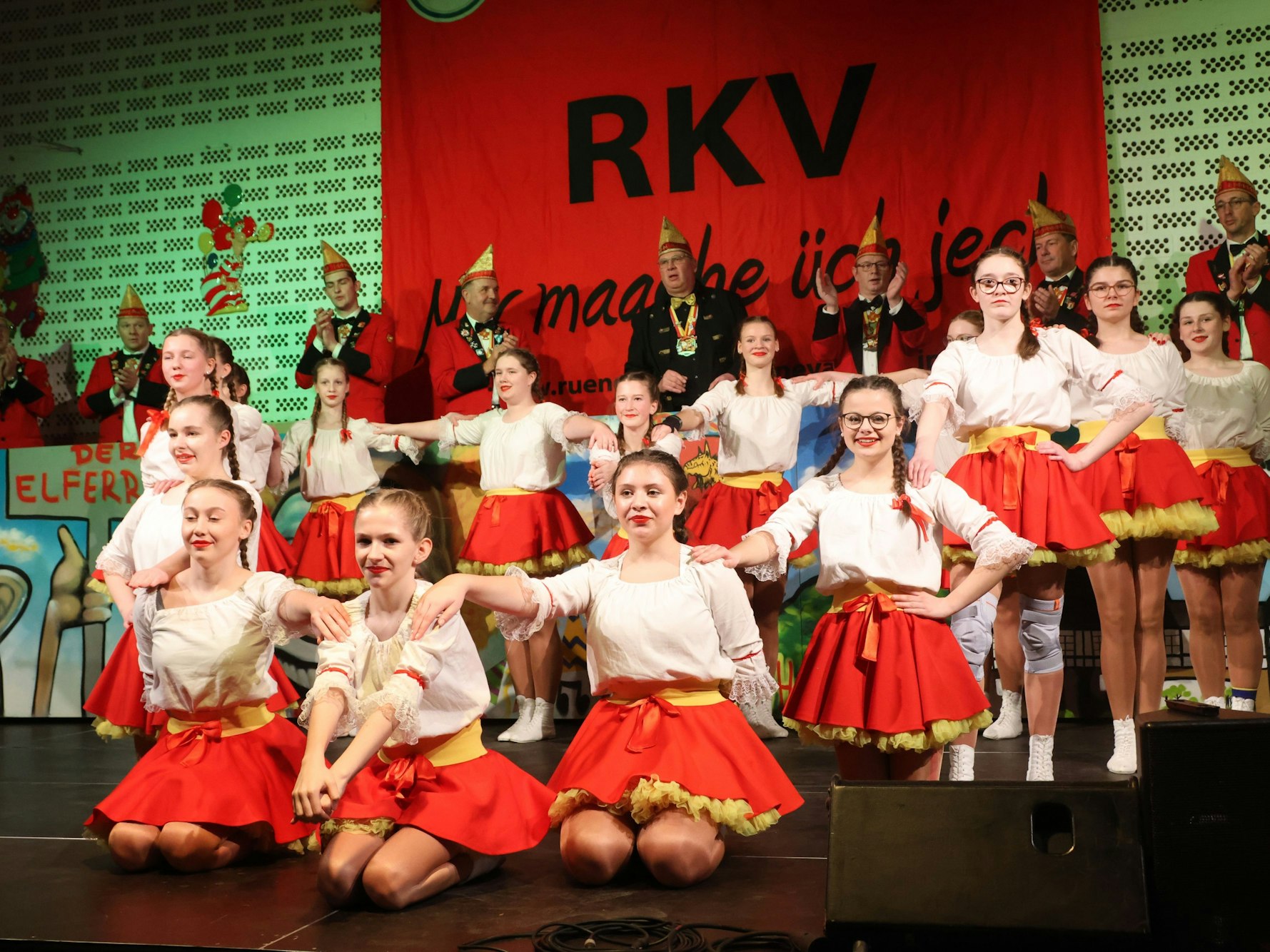 Zu sehen ist eine rot-weiß kostümierte Kindertanzgruppe.