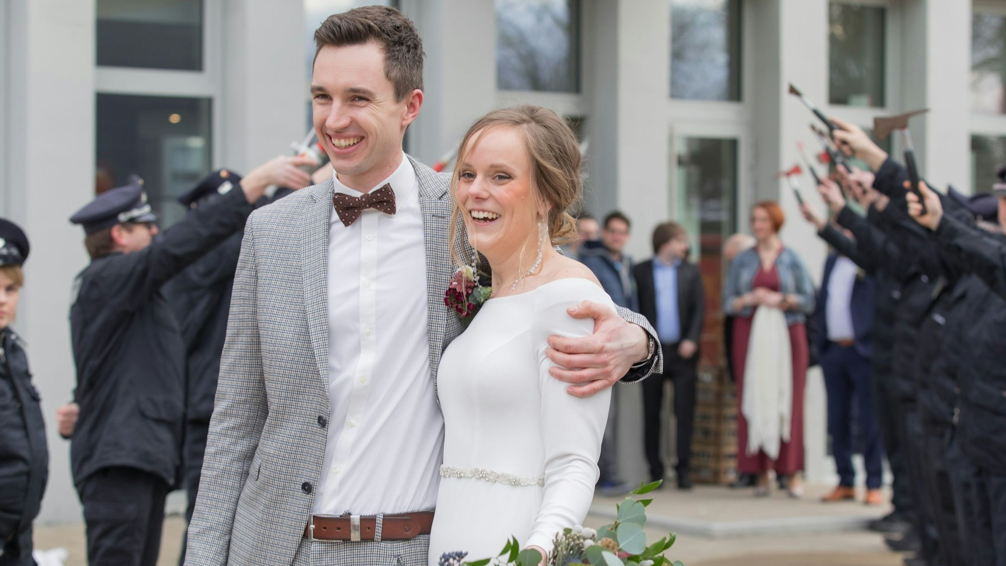 Das Brautpaar wird von Feuerwehrleuten begrüßt, die Spalier stehen.