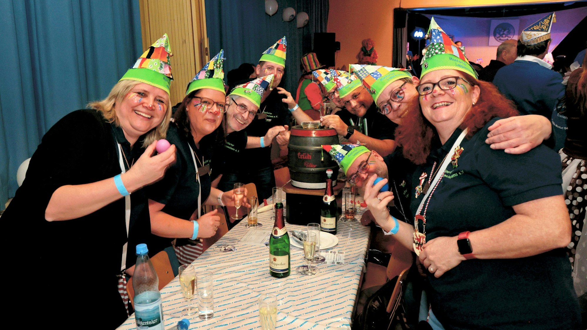 Gruppe Lappenclowns an einem Tisch mit Bierfass.