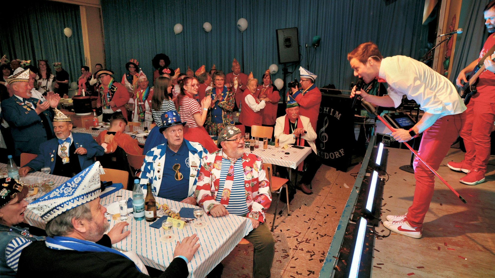 Musiker singt mit Mikrofon in Richtung Publikum