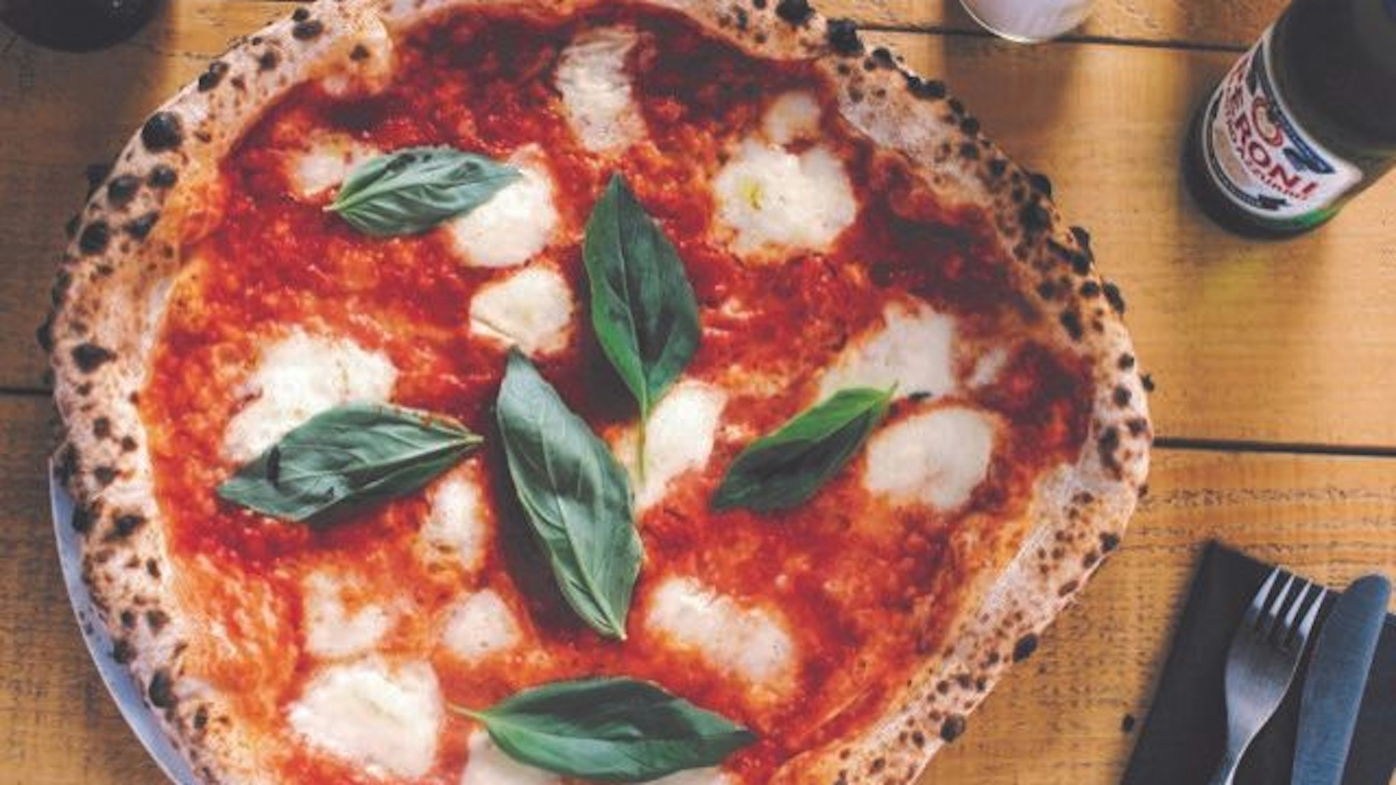 Eine Pizza mit Mozzarella und Basilikum