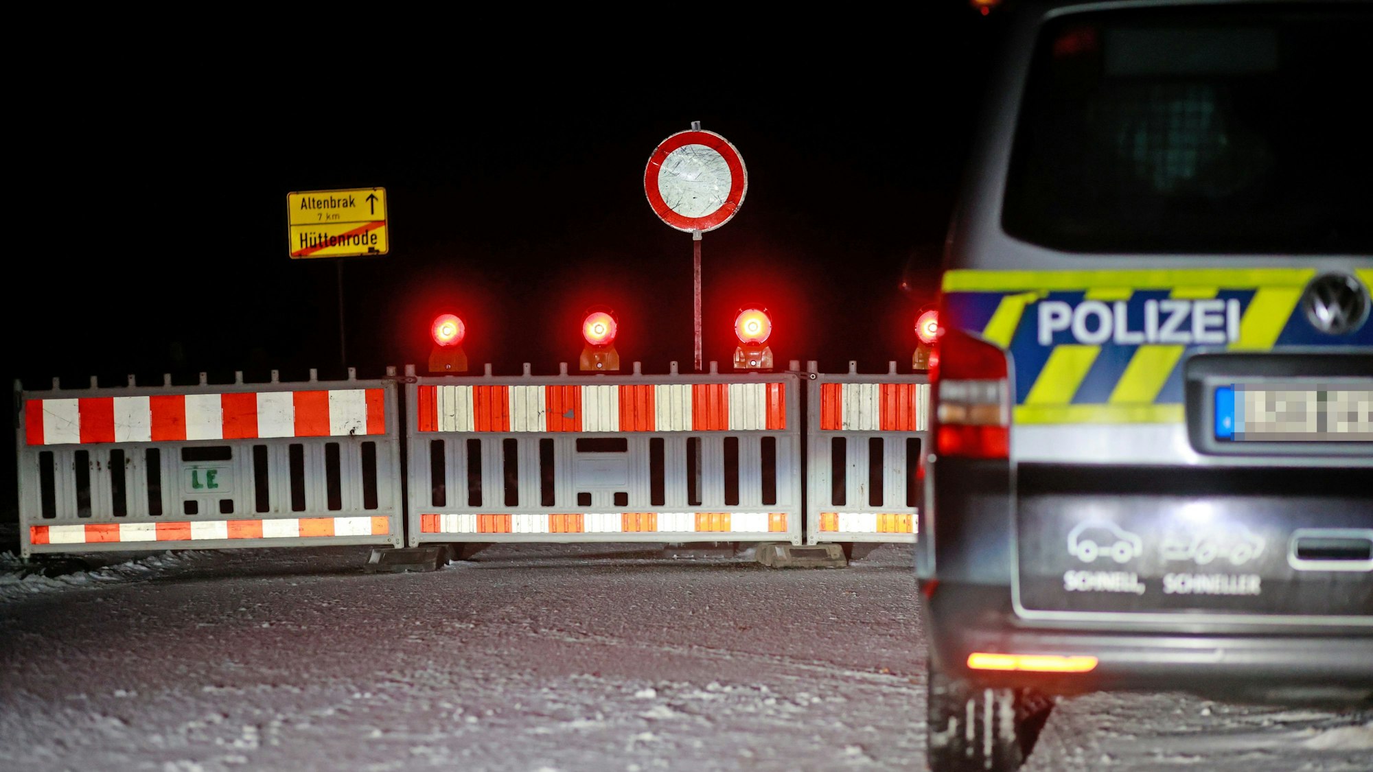 Es ist eine Straßensperrung zu sehen. Auf der rechten Seite steht ein Polizeiwagen.