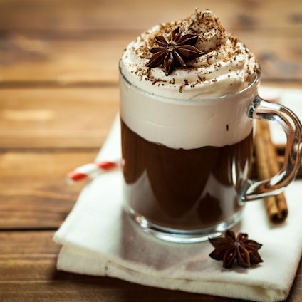 Heiße Schokolade mit Sahne, Zimt und Kakaopulver.