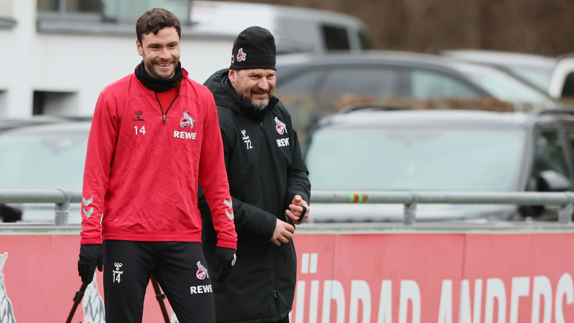 Jonas Hector und Steffen Baumgart lachen auf dem Trainingsgelände des 1. FC Köln.