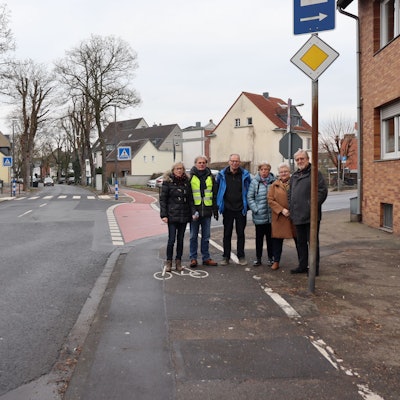 Die Anwohner stehen an der betroffenen Kreuzung, im Hintergrund ist der falsch gelegene Zebrastreifen zu sehen.