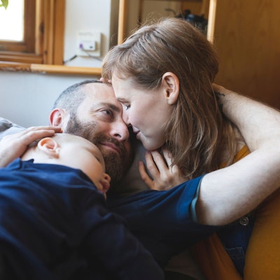 Ein Paar kuschelt, während ihr Baby schläft.