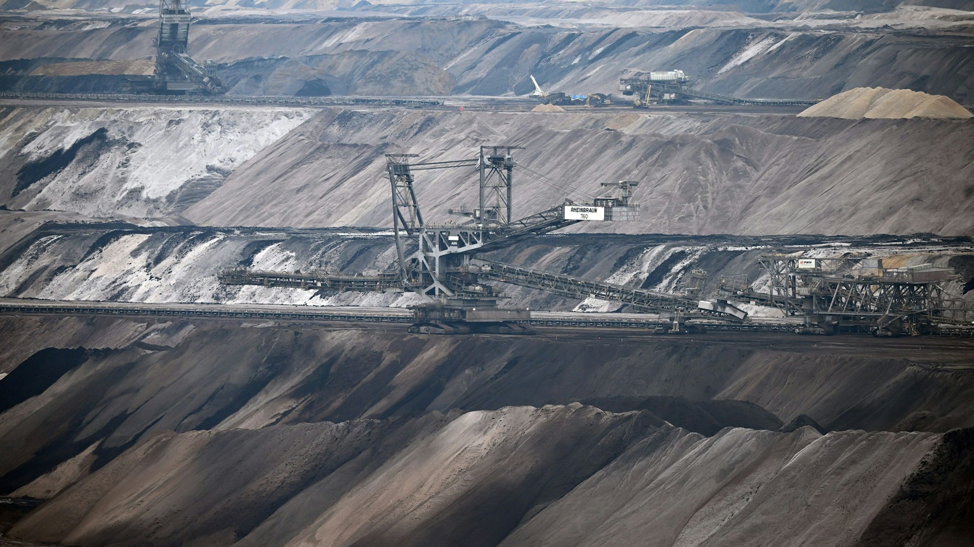 PRODUKTION - 23.01.2023, Nordrhein-Westfalen, Erkelenz: Bergbaumaschinen arbeiten im Tagebau Garzweiler. Die Stadt Erkelenz stellt eine geplante Bürgerbeteiligung «Zukunftsvision Tagebaurand» vor. Zum Stadtgebiet am Tagebau Garzweiler gehören fünf, bereits weitgehend leerstehende Dörfer, die wegen des vorzeitigen Braunkohleausstiegs erhalten bleiben. Foto: Federico Gambarini/dpa +++ dpa-Bildfunk +++