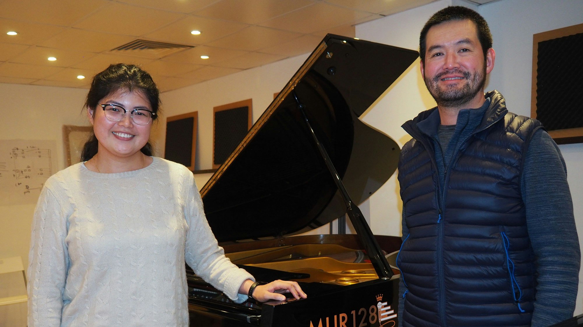 Joyce Kee steht mit ihrem Lehrer Yeow Hoay Aw im Proberaum an einem Klavier gelehnt.