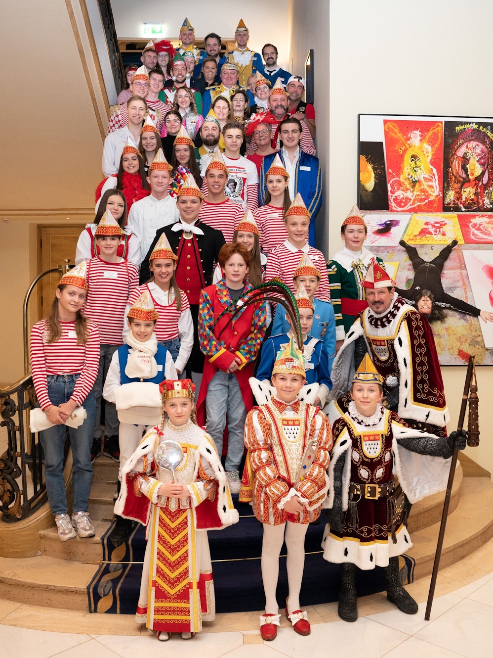 Das Bild zeigt das aktuelle Kinderdreigestirn und rund 60 ehemalige Kindertollitäten auf einer Treppe im Excelsior.
