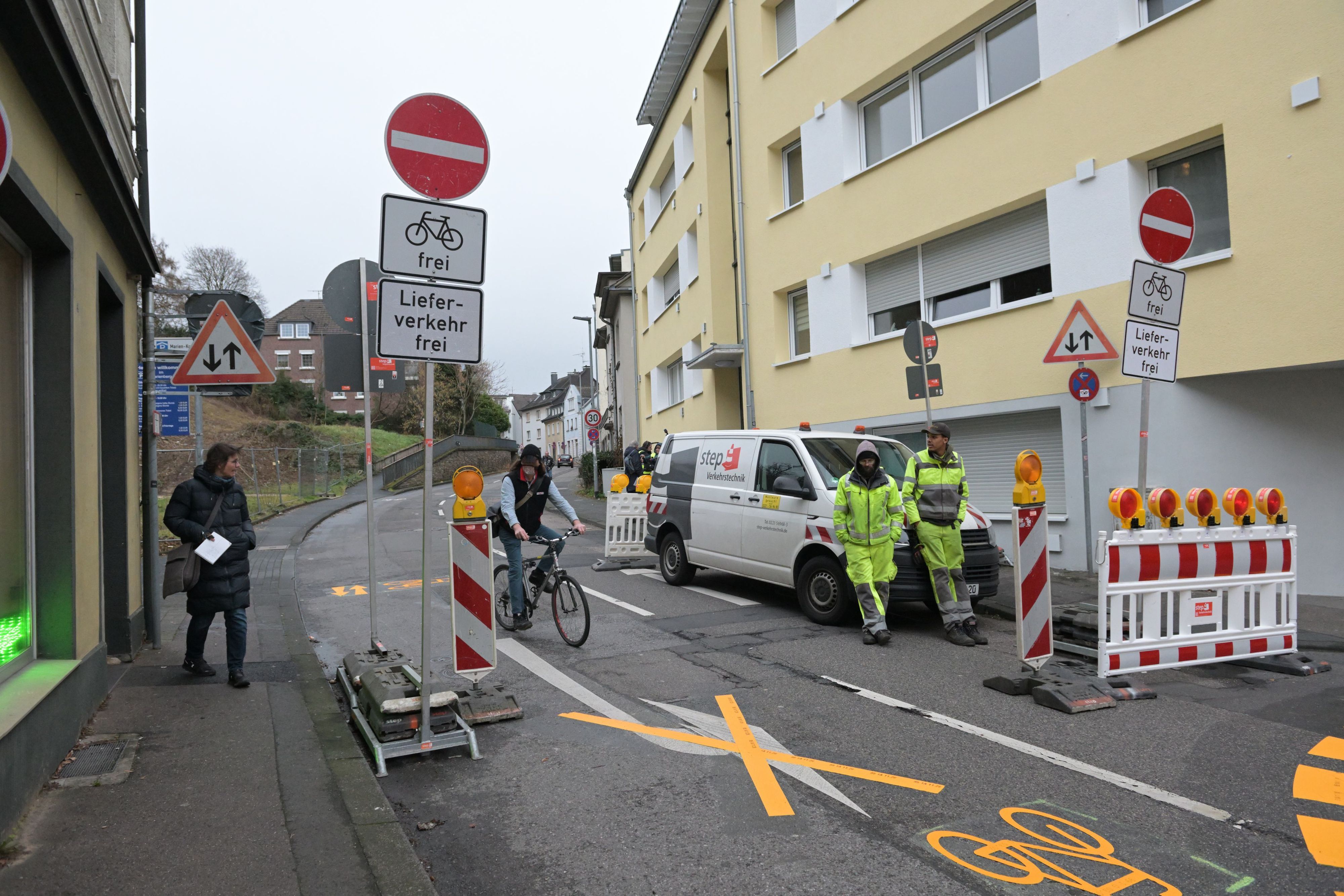 Fußgänger, Autofahrer und Radfahrer stehen an den Durchfahrt-Verboten-Schildern in der Bergisch Gladbacher Innenstadt.
