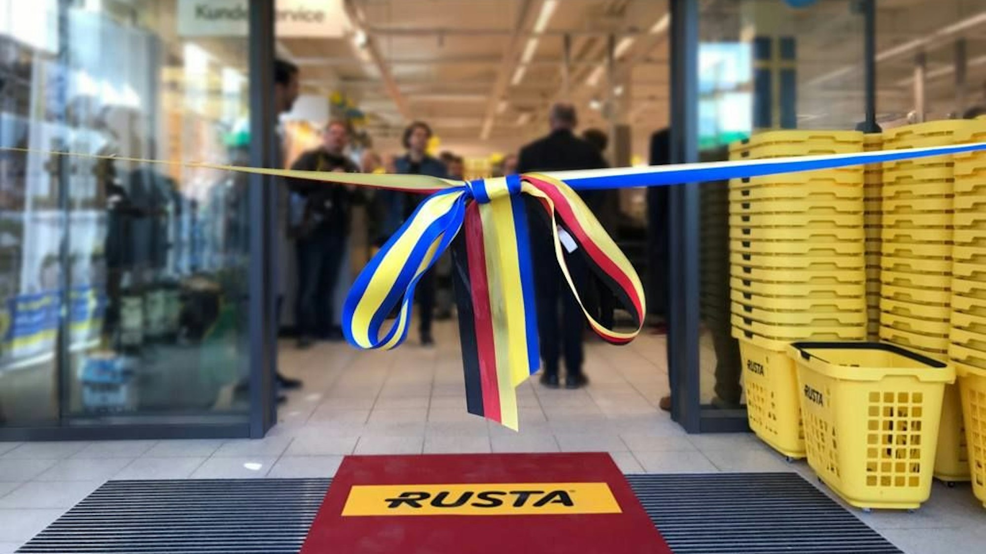 Das Foto zeigt eine Rusta-Filiale vor ihrer Eröffnung. Das Band vor der Tür ist noch nicht durchschnitten.