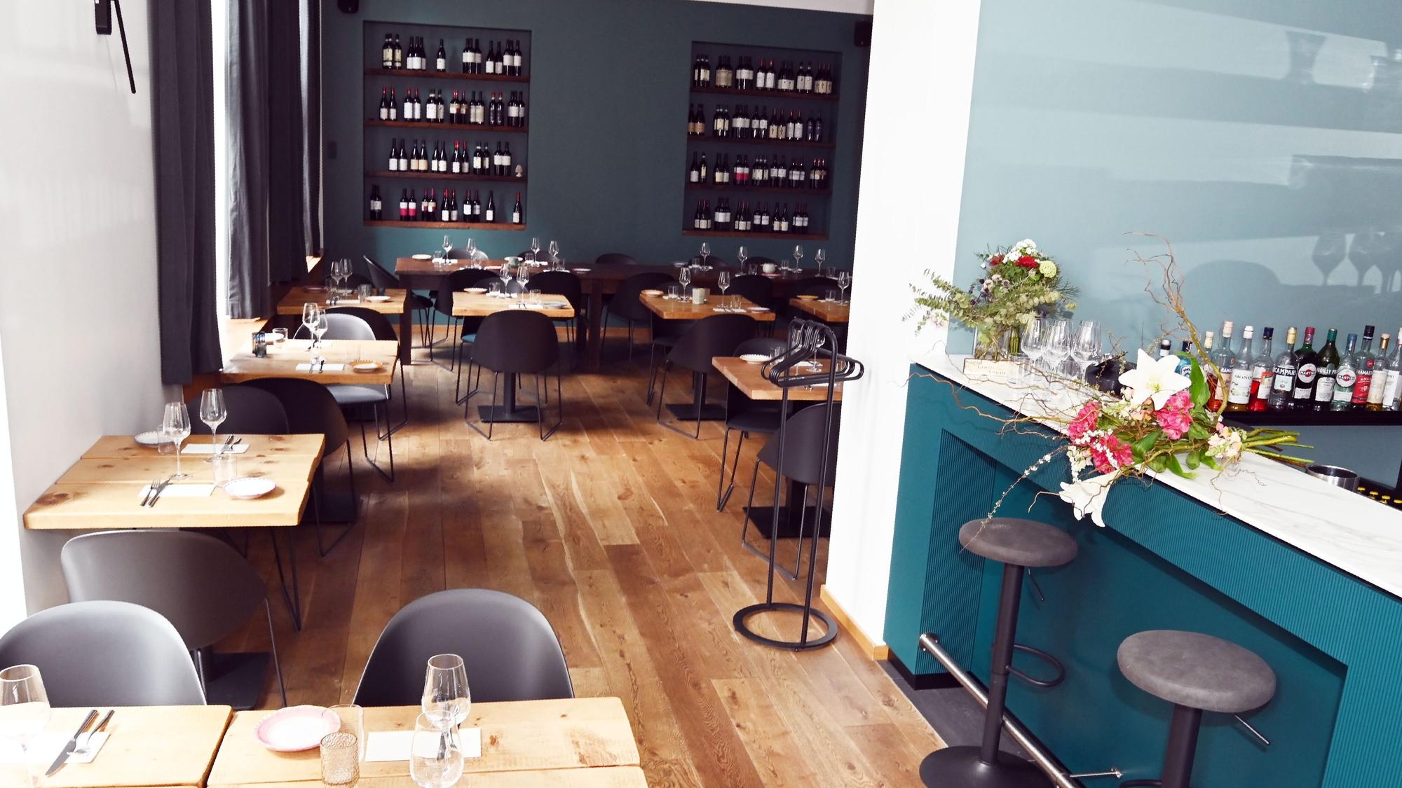 Das Interieur der Caruso Pasta Bar auf der Kasparstraße mit viel Holz und türkisen Farbtönen.