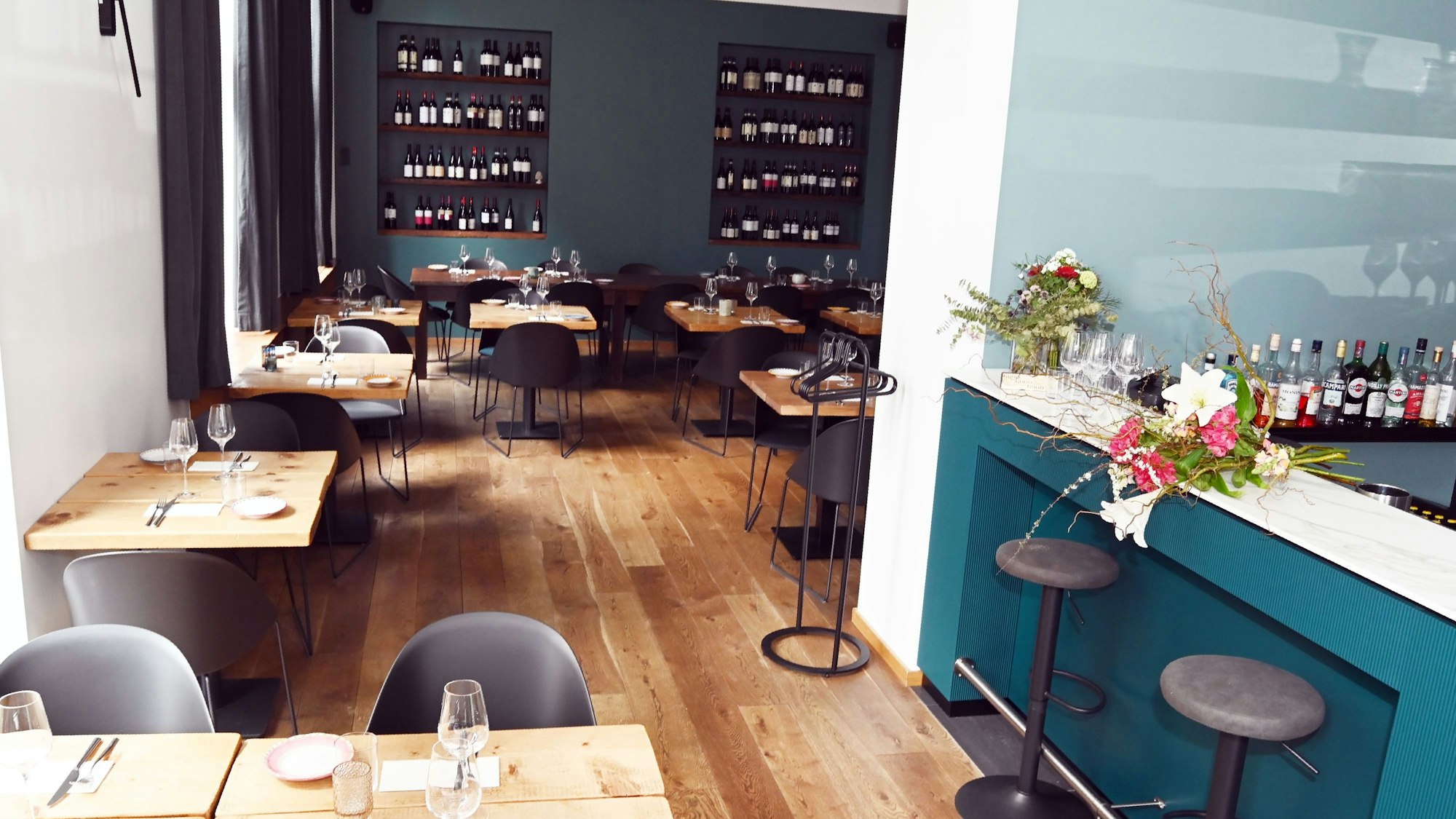 Das Interieur der Caruso Pasta Bar auf der Kasparstraße mit viel Holz und türkisen Farbtönen.