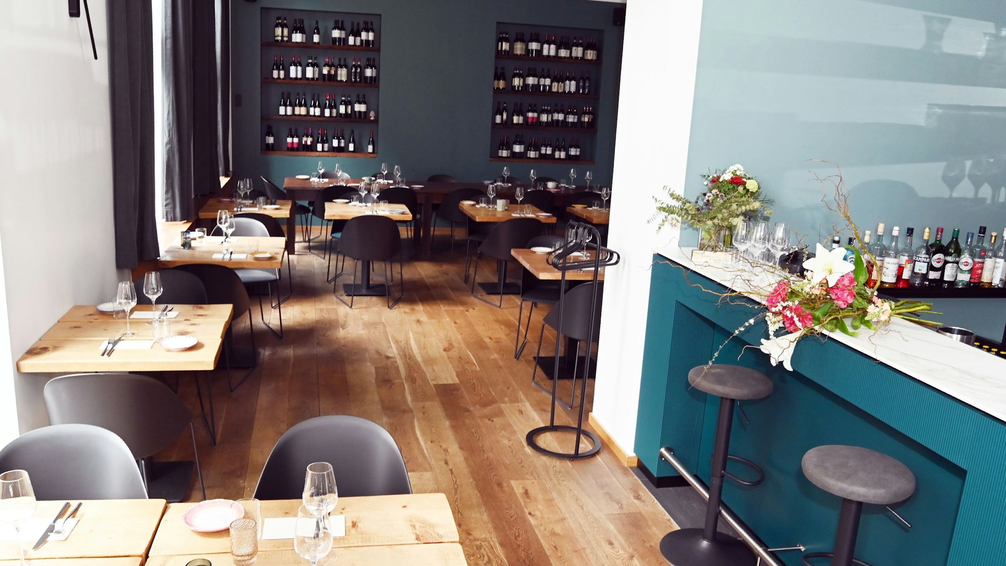 Die Pasta Bar Caruso in Köln von innen mit moderner Einrichtung und Weinflaschen in Regalen