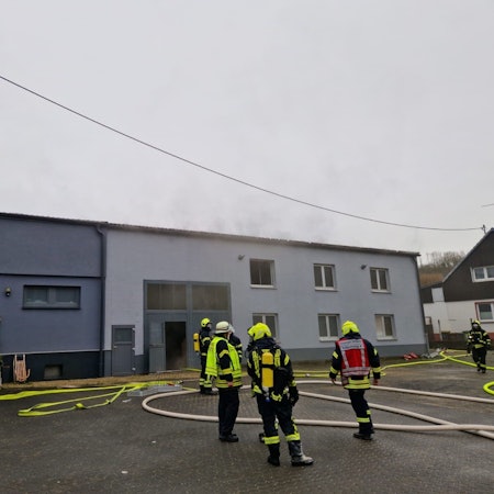 Feuer in einer Erdgeschosswohnung. Feuerwehrleute löschen den Brand.