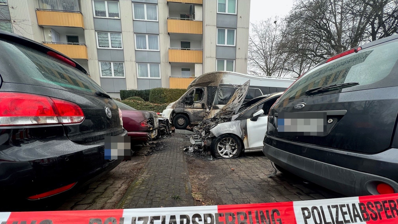 Mehrere ausgebrannte Autos auf einem Parkplatz in Köln-Porz.