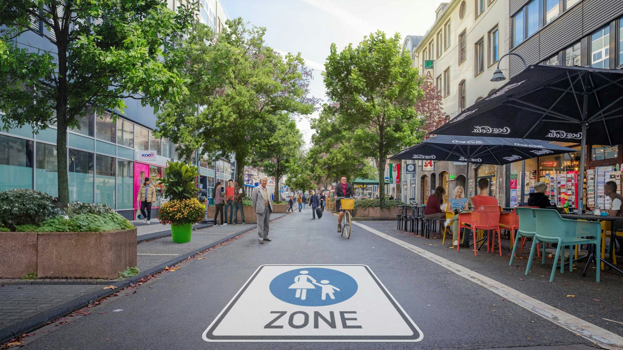Auf einer Straße prangt riesengroß das Piktogramm für Fußgängerzone. Rechts sind Stühle und Tische eines Cafés zu sehen, Radler und Fußgänger sind auf der Straße unterwegs.