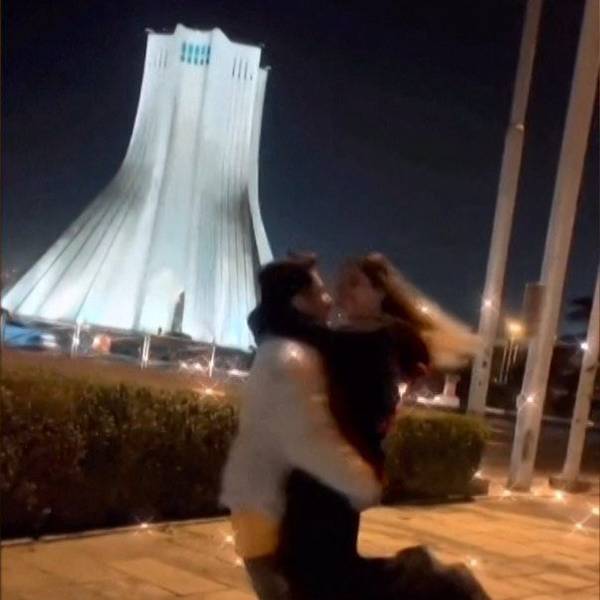 Ein junges Paar tanzt und umarmt sich vor Freiheitsturm in Teheran.